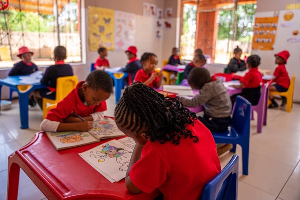 Learners busy with colouring activities in a bright classroom at Heaven's Rainbow Academy
